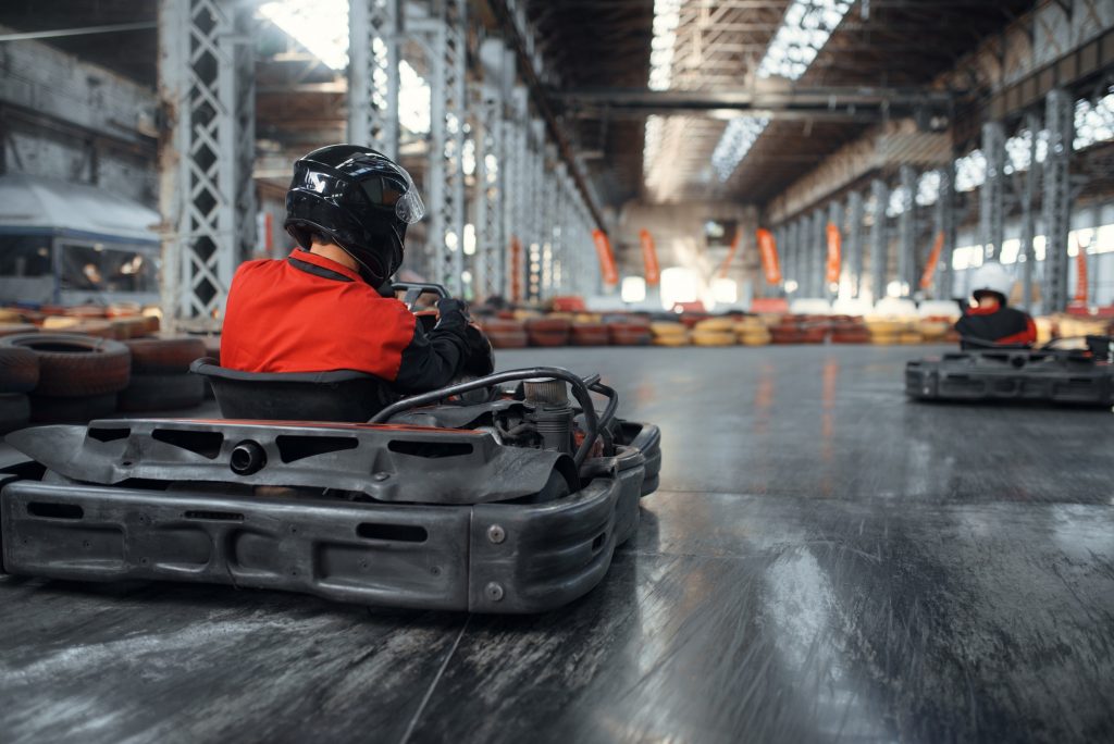 Racer in helmet driving go kart car